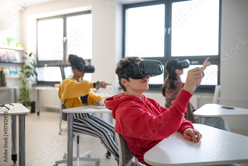 Teenage students wearing virtual reality goggles at school in computer science class photo