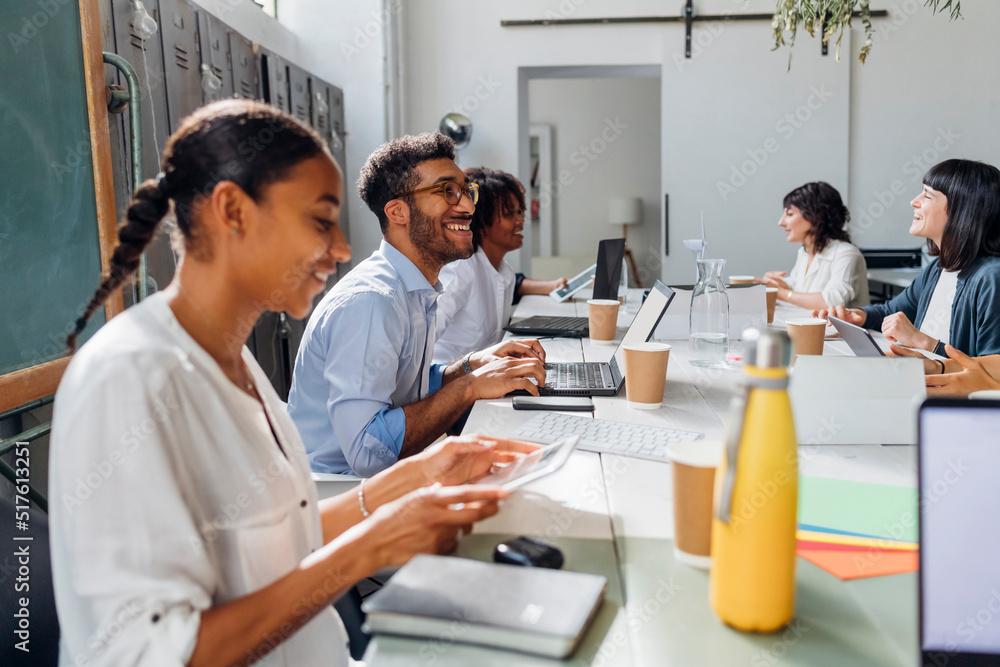 Happy multiracial business colleagues working at desk in coworking office Happy multiracial business colleagues working at desk in coworking office