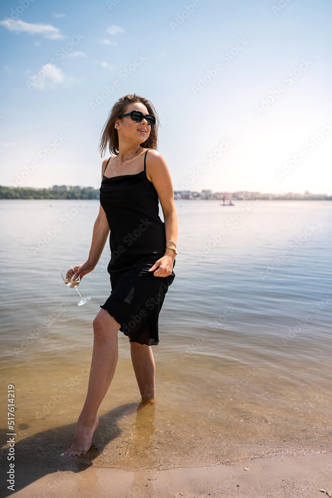 beautiful woman barefoot walks by the lake, warm water beautiful woman barefoot walks by the lake, warm water