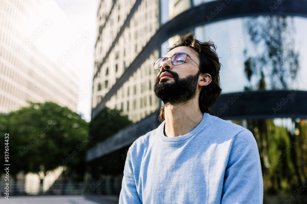 Bearded man with eyes closed in city Bearded man with eyes closed in city