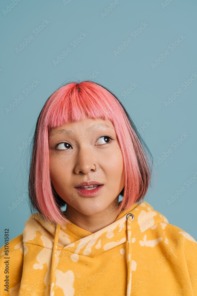 Asian girl with pink hair and piercing posing while looking aside Asian girl with pink hair and piercing posing while looking aside