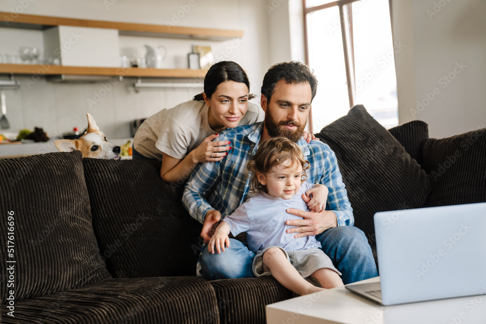 Smiling family on a video call via laptop computer Smiling family on a video call via laptop computer