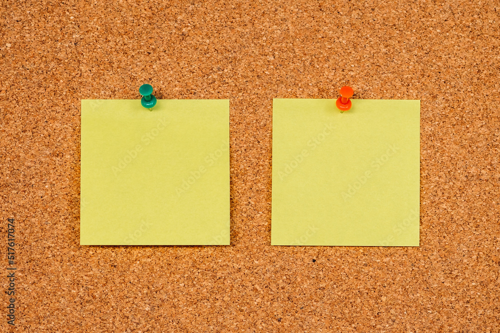 Two Yellow Post-it Sticky Notes on a cork board with drawing pins. Copy space Two Yellow Post-it Sticky Notes on a cork board with drawing pins. Copy space