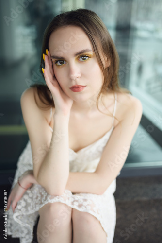 City portrait of beautiful young woman in white dress.