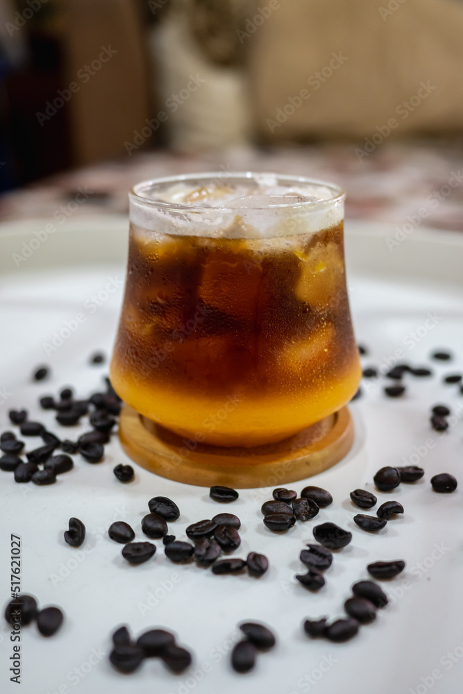 a glass of orange coffee on white table. a glass of orange coffee on white table.