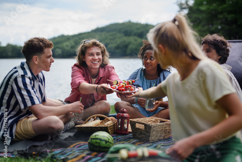 Group of multiracial young friends camping near lake and and having barbecue together, looking at camera. #517621078