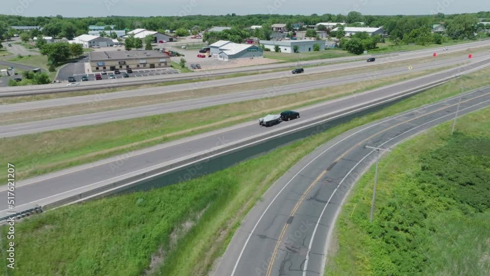 suv hauling a covered boat down the road and onto a highway suv hauling a covered boat down the road and onto a highway