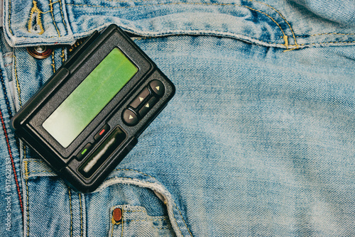 Pager is an old retro gadget for communication on jeans. photo