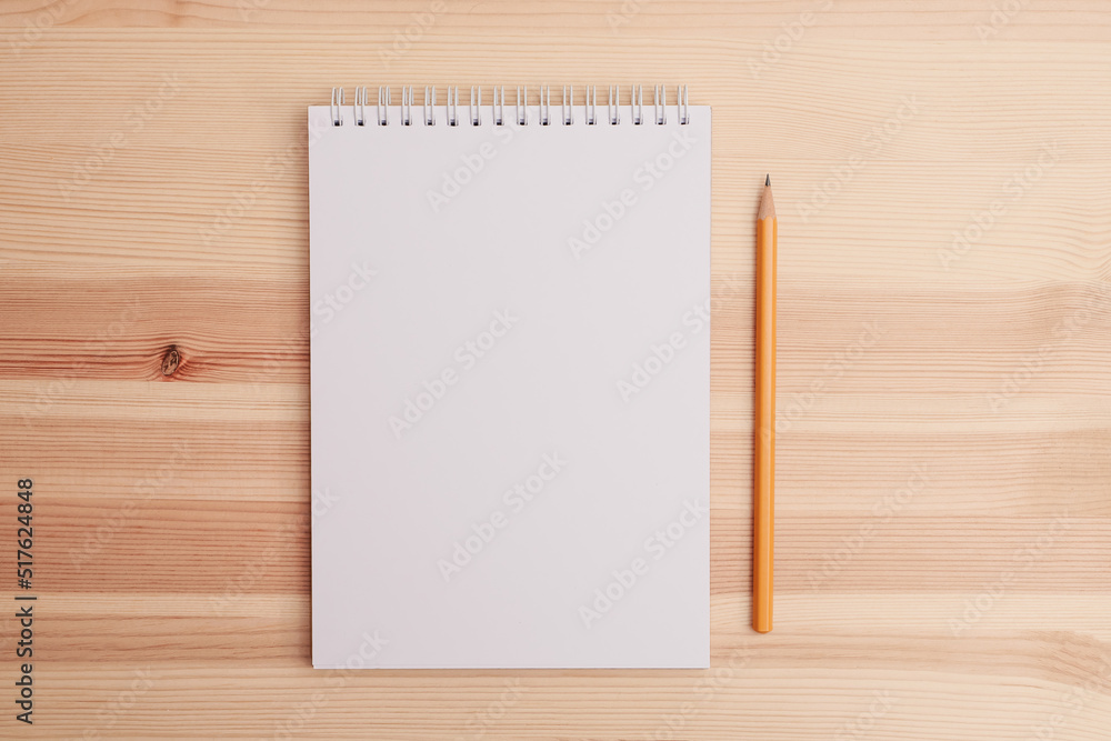 Top view on sketchbook and pencil on wooden table Top view on sketchbook and pencil on wooden table