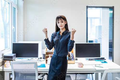 A businesswoman in an office with a black shirt and skirt