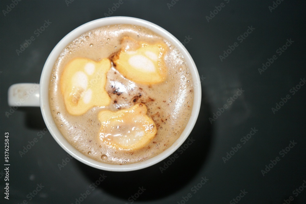 a cup of coffee with marshmallow bear shape topping
