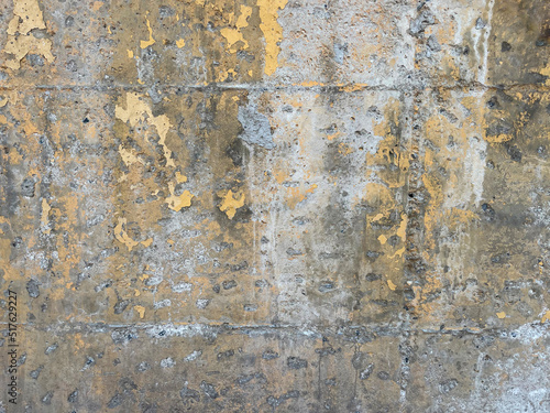 Old weathered plastered concrete wall texture, old dirty flaky concrete wall with damaged yellow painting, grunge texture