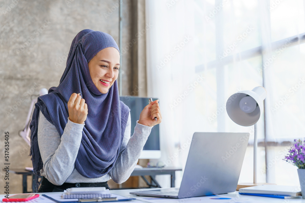 Young muslim woman working in business office, wearing Hijab works as start up SMEs project, Success, win, glad, gleeful, cheerful, victory.
