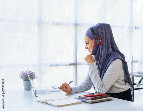 Young muslim woman working in business office, wearing Hijab works as start up SMEs project, online working, video call conference.