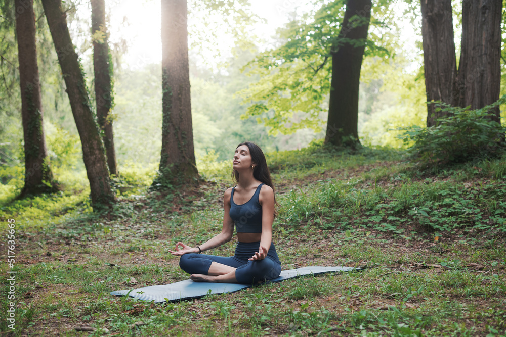 Woman practicing meditation in the forest Woman practicing meditation in the forest