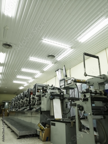 Used modern multi-color roll printing machine for the production of self-adhesive labels. Equipment for printing house. Selective focus