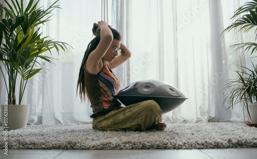 Woman playing a hang drum at home photo