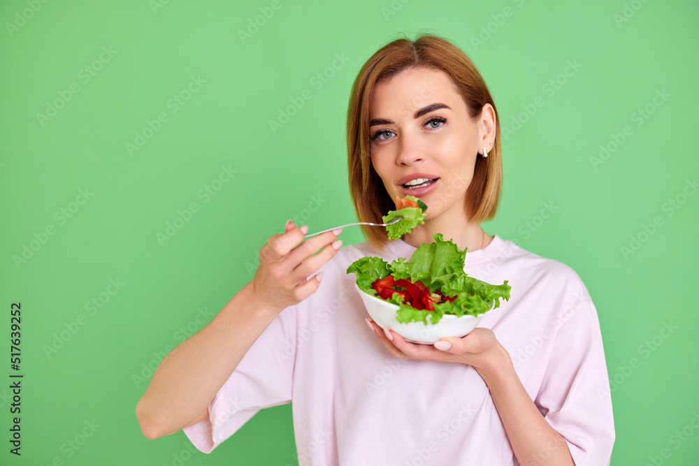 beautiful woman eating fresh vegetable salad on white background beautiful woman eating fresh vegetable salad on white background