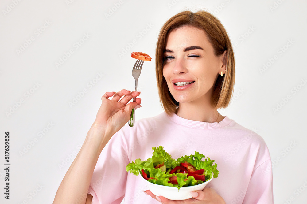beautiful woman eating fresh vegetable salad on white background beautiful woman eating fresh vegetable salad on white background