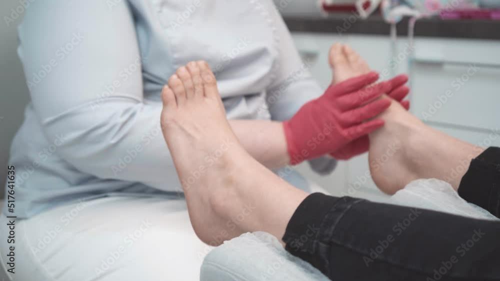 Close up on a podiatrist hands treating feet during procedure Close up on a podiatrist hands treating feet during procedure