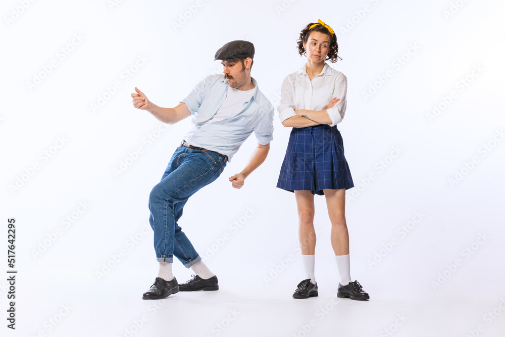 Portrait of young stylish woman and dancing cheerful man posing isolated over white studio background Portrait of young stylish woman and dancing cheerful man posing isolated over white studio background