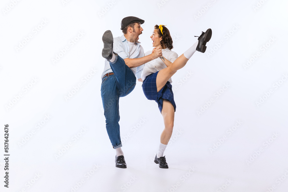 Portrait of young emotive couple, man and woman, dancing boogie woogie isolated over white studio background. Excitement Portrait of young emotive couple, man and woman, dancing boogie woogie isolated over white studio background. Excitement