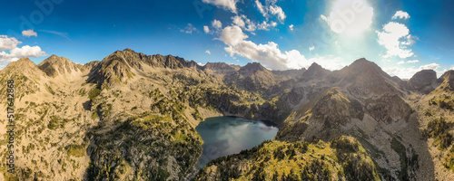 Espectacular valle con lago rodeado de picos montañosos en día soleado