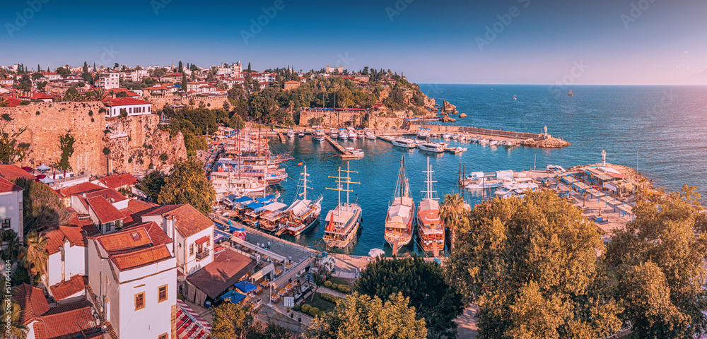 Aerial sunset view of the picturesque harbor with marina port with cruise tourist ships near the old town of Kaleici in Antalya. Turkish Riviera and resort paradise