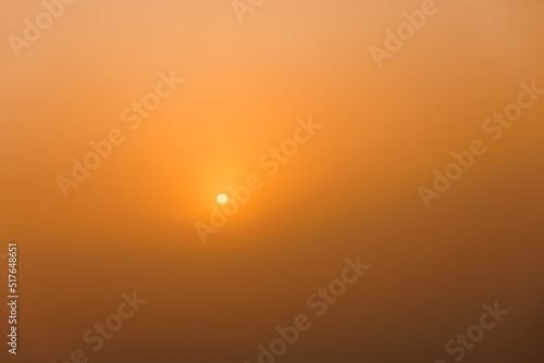 rising sun on clear golden gradient sky with visible spots in the sun, without horizon, minimalistic empty composition, shot on 80mm telephoto lens on full-frame 35mm sensor camera photo