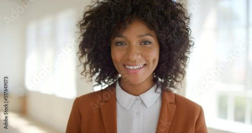 Businesswoman woman smiling in office. African lady with cute dimples puts a smile on her face standing in the workplace. Intern ready to help grow the company by adding value in the corporate space photo