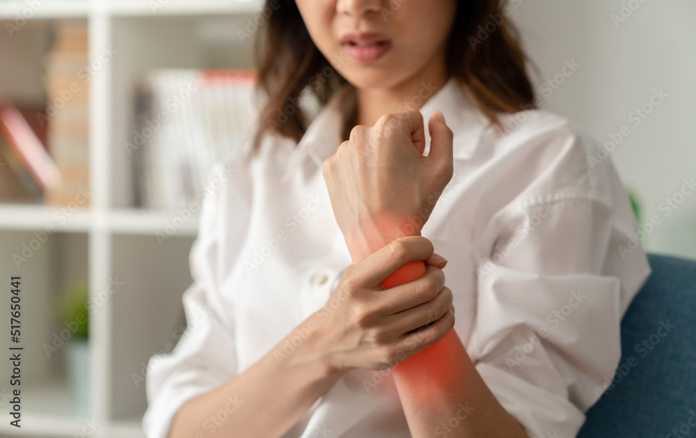 Close up of unhappy young woman having wrist pain in hand, Office Syndrome and chronic disease from injury. Close up of unhappy young woman having wrist pain in hand, Office Syndrome and chronic disease from injury.