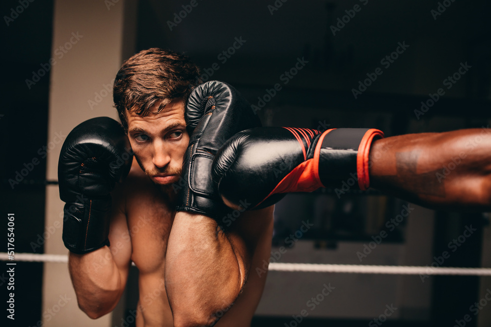 Boxing athlete blocking a punch to his jaw Boxing athlete blocking a punch to his jaw