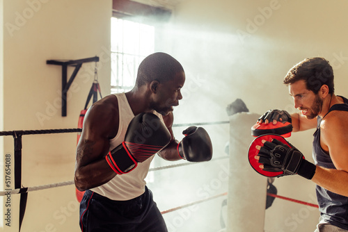 Boxing instructor training a young fighter in a gym