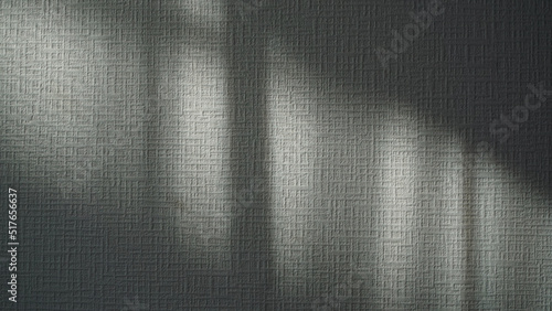 窓から室内に照らされる壁紙に映った太陽の光と影