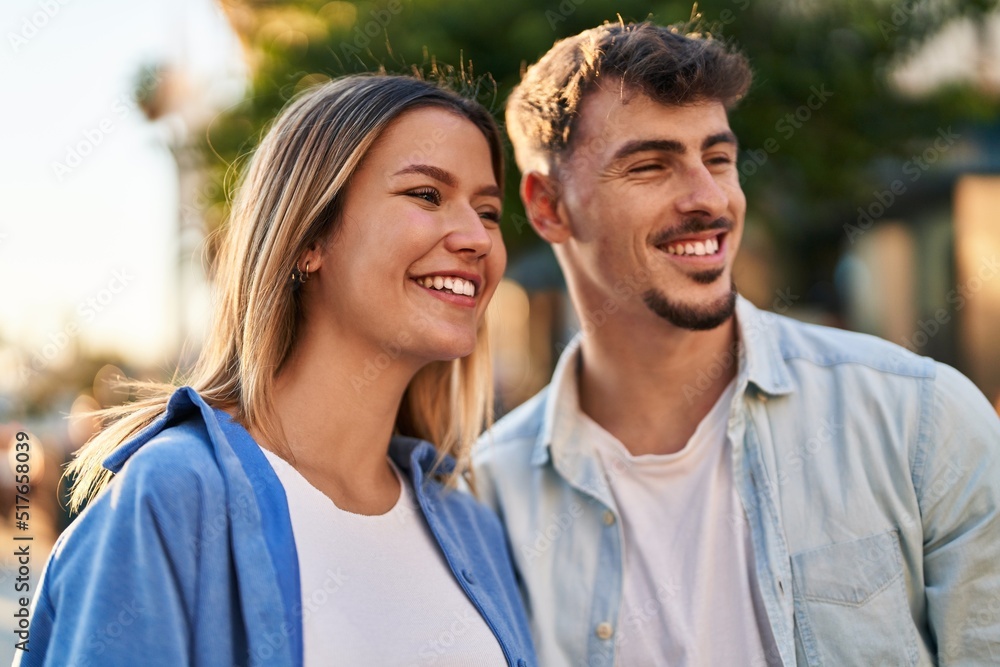 Fototapeta premium Young man and woman couple smiling confident standing together at street