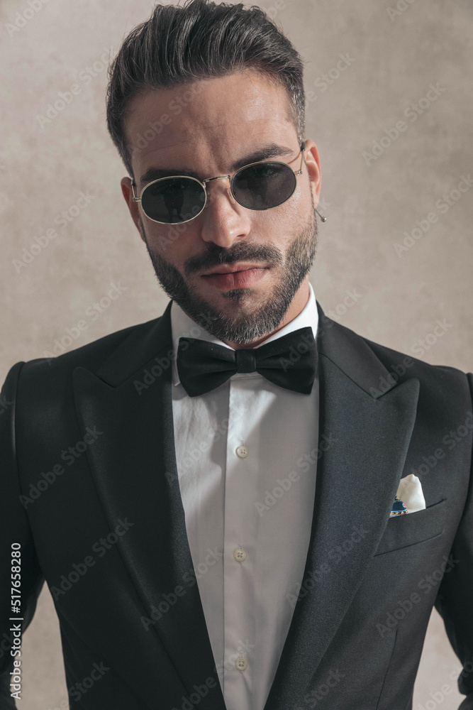 bearded young man in elegant tux with glasses posing bearded young man in elegant tux with glasses posing