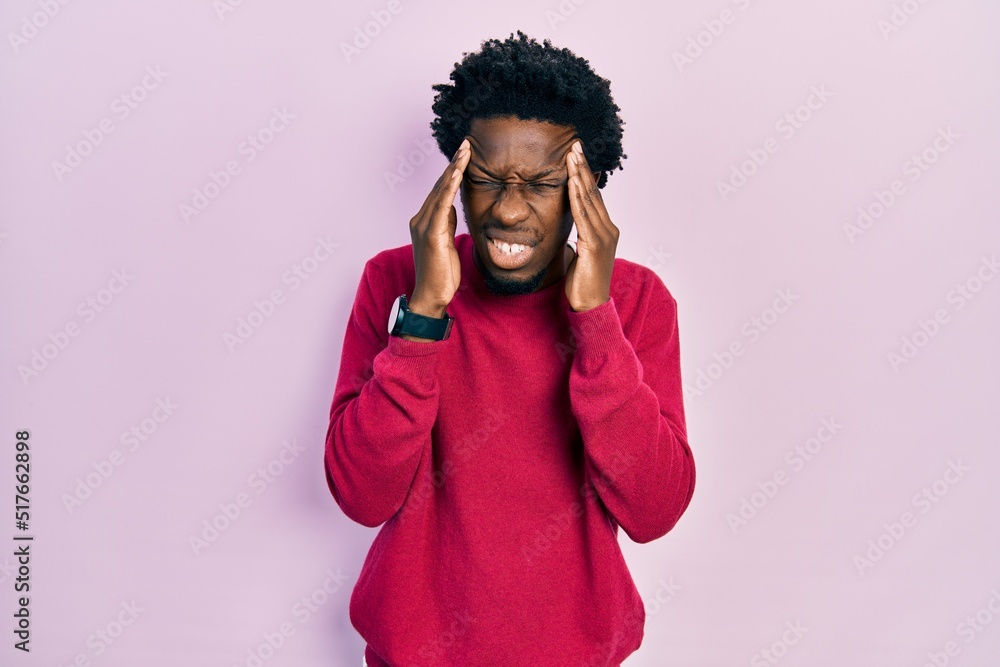 Young african american man wearing casual clothes with hand on head, headache because stress. suffering migraine. Young african american man wearing casual clothes with hand on head, headache because stress. suffering migraine.