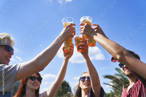 Group of caucasian friends make toasting beer at festival