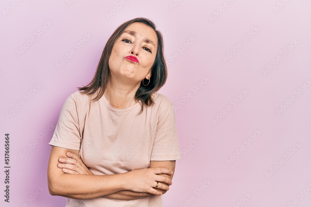 Middle age hispanic woman with arms crossed gesture looking at the camera blowing a kiss being lovely and sexy. love expression. Middle age hispanic woman with arms crossed gesture looking at the camera blowing a kiss being lovely and sexy. love expression.