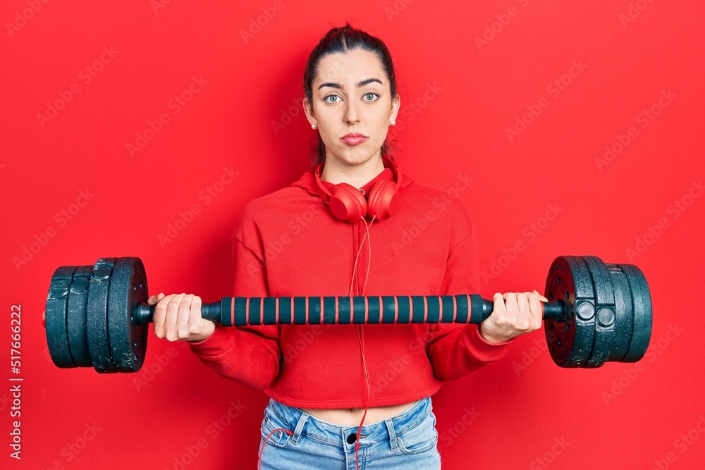 Beautiful woman with blue eyes wearing sportswear using dumbbells depressed and worry for distress, crying angry and afraid. sad expression. Beautiful woman with blue eyes wearing sportswear using dumbbells depressed and worry for distress, crying angry and afraid. sad expression.