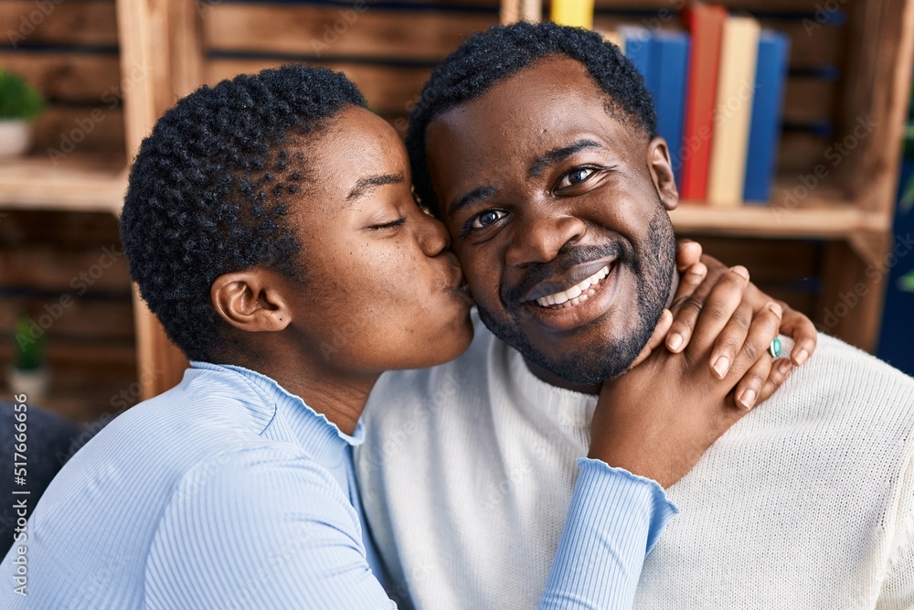 Man and woman couple hugging each other sitting on sofa at home Man and woman couple hugging each other sitting on sofa at home