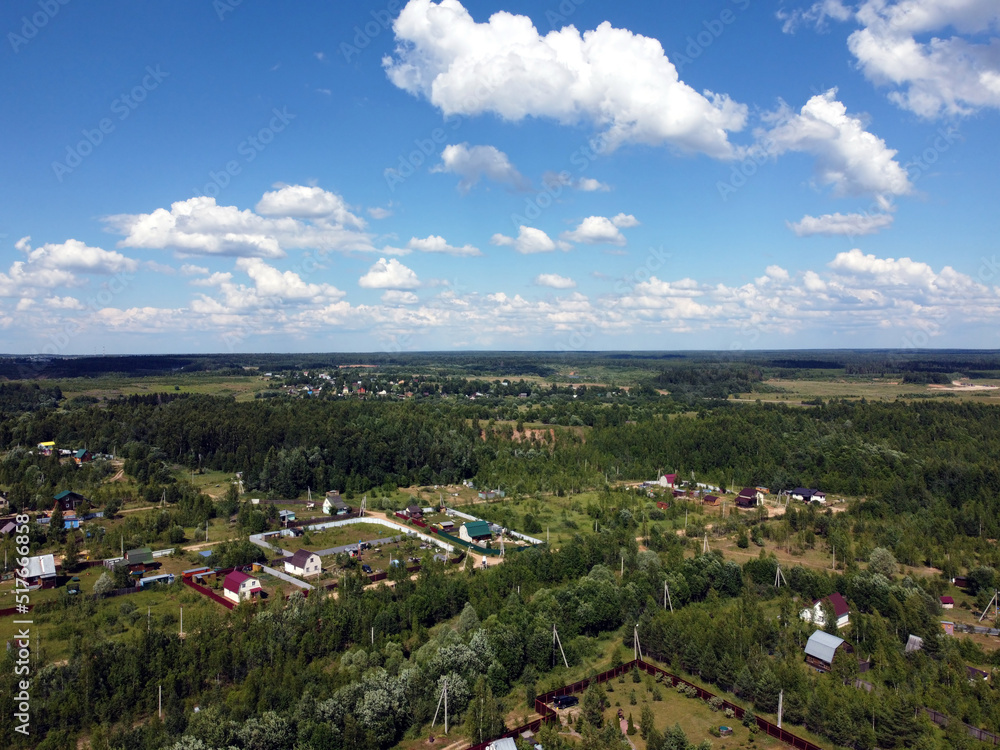 Countryside landscape with many private houses with homesteads in the the middle band of Russia in the bright sunny summer day aerial view