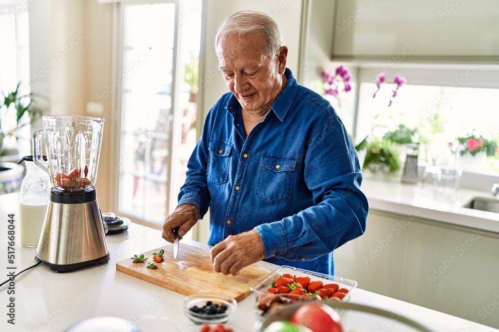 Senior man smiling confident cutting datil at kitchen Senior man smiling confident cutting datil at kitchen