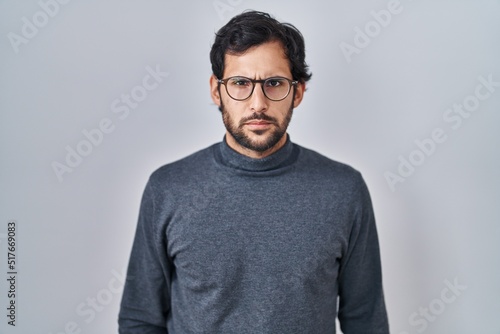 Handsome latin man standing over isolated background skeptic and nervous, frowning upset because of problem. negative person. © Krakenimages.com