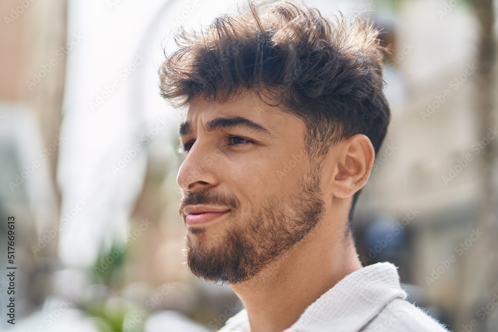 Young arab man smiling confident looking to the side at street Young arab man smiling confident looking to the side at street