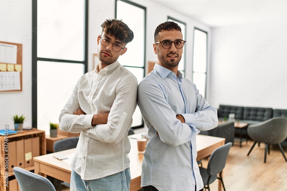 Two hispanic men business workers standing with arms crossed gesture at office Two hispanic men business workers standing with arms crossed gesture at office