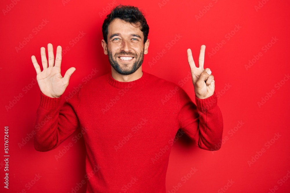 Handsome man with beard wearing casual red sweater showing and pointing up with fingers number seven while smiling confident and happy. Handsome man with beard wearing casual red sweater showing and pointing up with fingers number seven while smiling confident and happy.