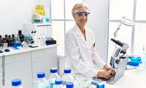 Middle age blonde woman wearing scientist uniform working at laboratory