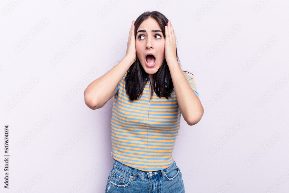 Young caucasian woman isolated on pink background covering ears with hands trying not to hear too loud sound. Young caucasian woman isolated on pink background covering ears with hands trying not to hear too loud sound.