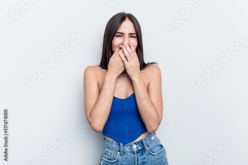 Young caucasian woman isolated on white background laughing about something, covering mouth with hands. © Asier